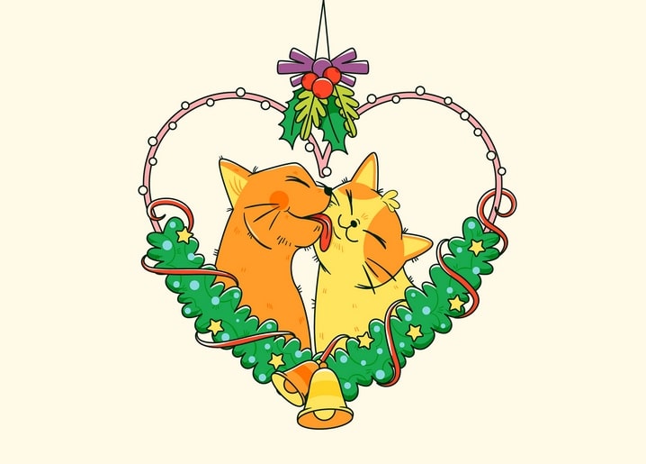 Two ginger cats nuzzling nose to nose inside a heart wreath with mistletoe and bells