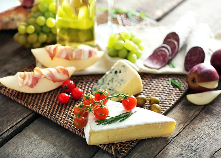 Käseplatte mit Brie, Blauschimmelkäse, Prosciutto-Melone und Trauben