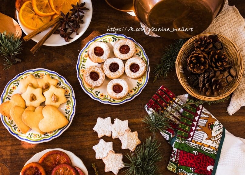 Weihnachtsplätzchen, Orangenscheiben, Zimtstangen und Sternanis auf dem Tisch