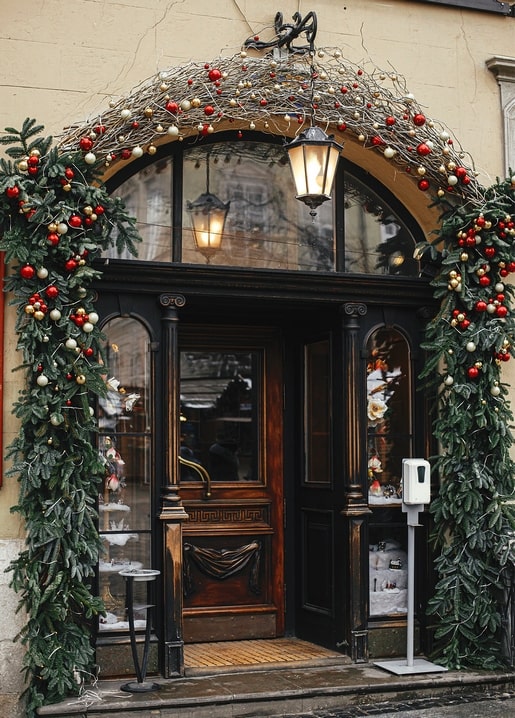 Wooden shop entrance decorated with fir garlands, ornaments, and glowing lanterns