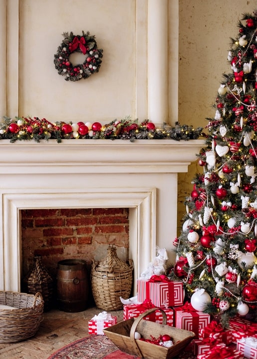 Christmas fireplace with wreath, lit garland, decorated tree and wrapped gifts
