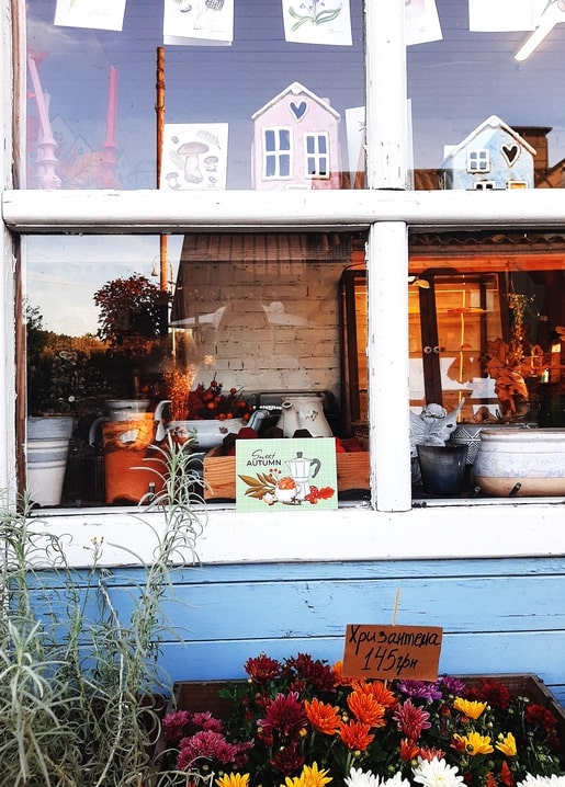 Wooden flower booth at VDNG with chrysanthemums for sale and a ‘Sweet Autumn’ sign