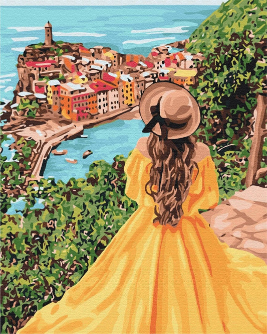 Cliffside view of a pastel harbor town below a woman in a golden dress and sunhat