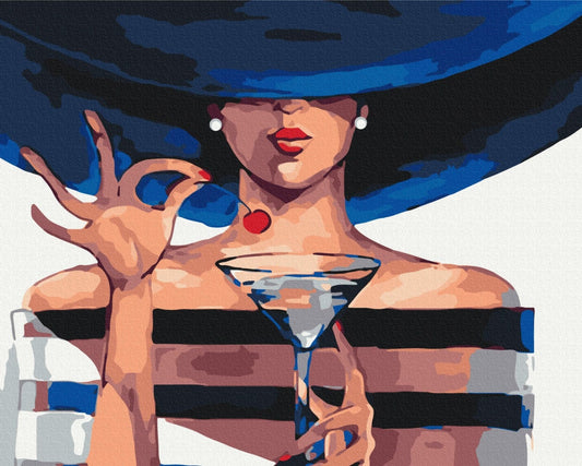 Frau mit breitem dunklem Hut hält einen Cosmopolitan-Cocktail mit Kirschgarnitur