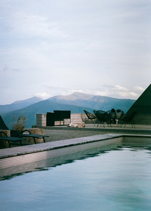 Infinity pool reflecting Carpathian mountains at Dragobrat, dog resting nearby
