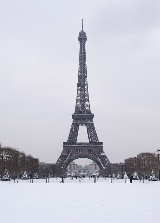Eiffel Tower over a snow-covered Champ de Mars under a grey sky