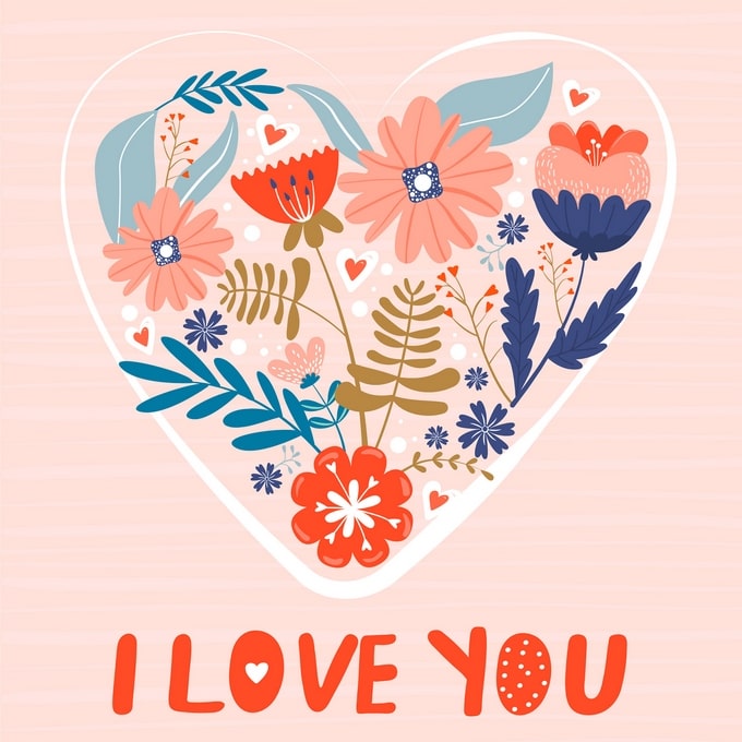 Heart-shaped wreath of orange, navy and pink flowers with an ‘I Love You’ message on pink stripes