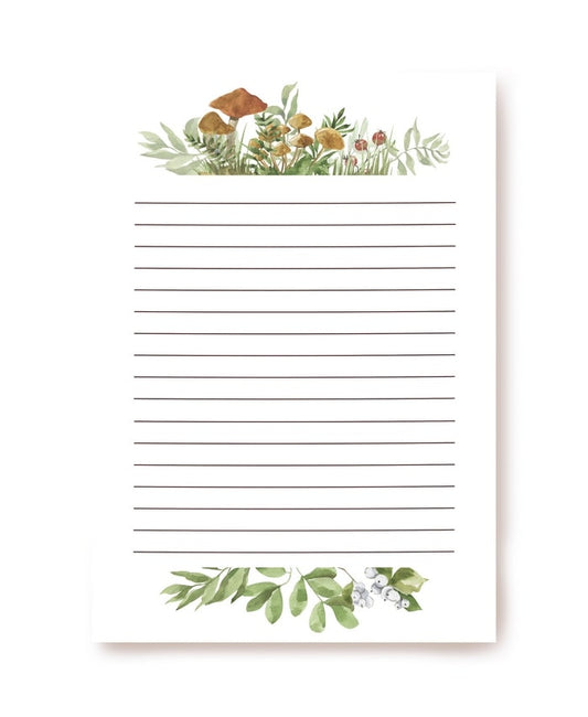 Writing paper bordered with chanterelle mushrooms, ferns, and berries top and bottom