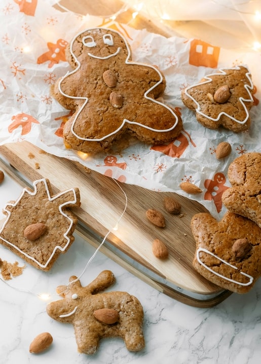 Gingerbread cookies shaped like men, trees, and a reindeer, decorated with almonds