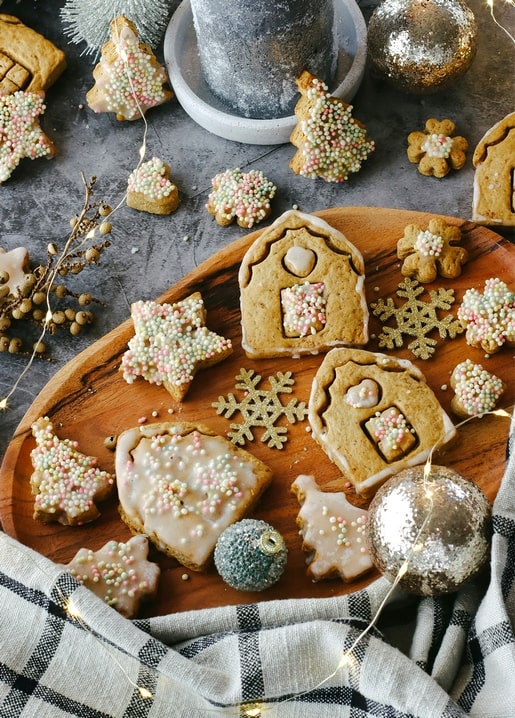 Frosted gingerbread house, stars and snowflake cookies with fairy lights and ornaments