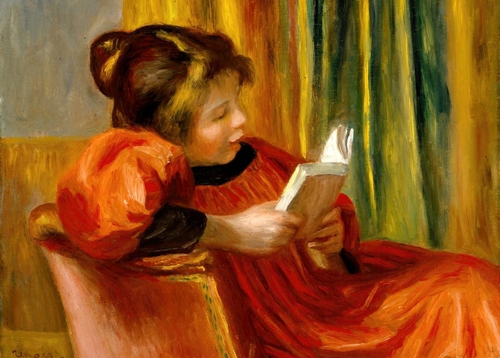 Renoir painting of a girl in a red dress reading a book in an armchair