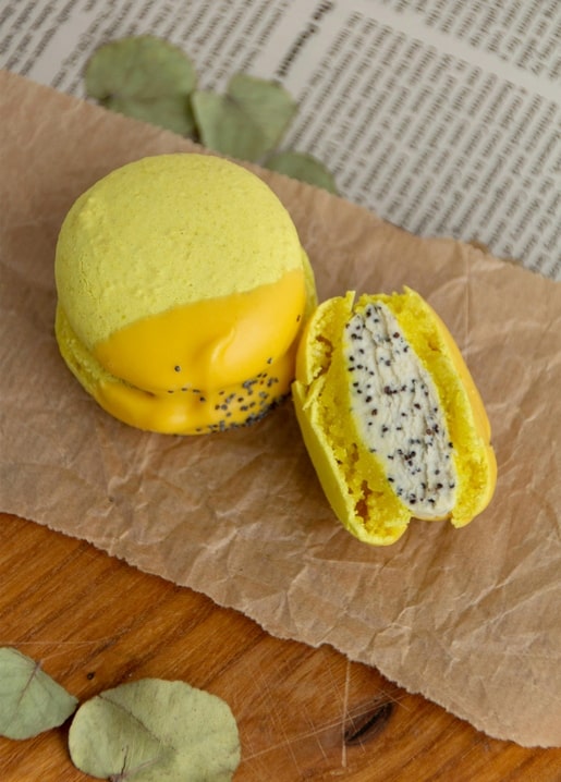 Aufgeschnittenes Gebäck mit gelb-oranger Glasur und Mohn-Sahnecreme