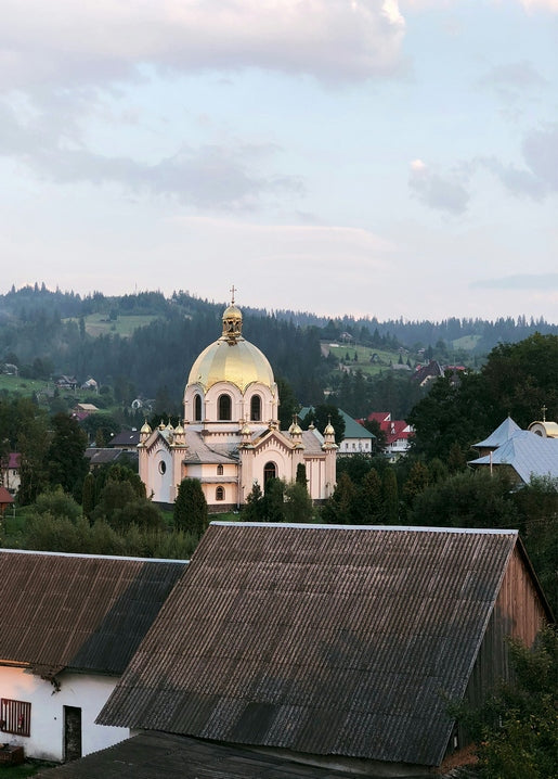 Golden-domed church above wooden rooftops in Slavsko, Carpathian Mountains
