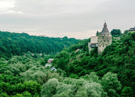 Goncharska Tower rising above green forested hills in Kamianets-Podilskyi, Ukraine