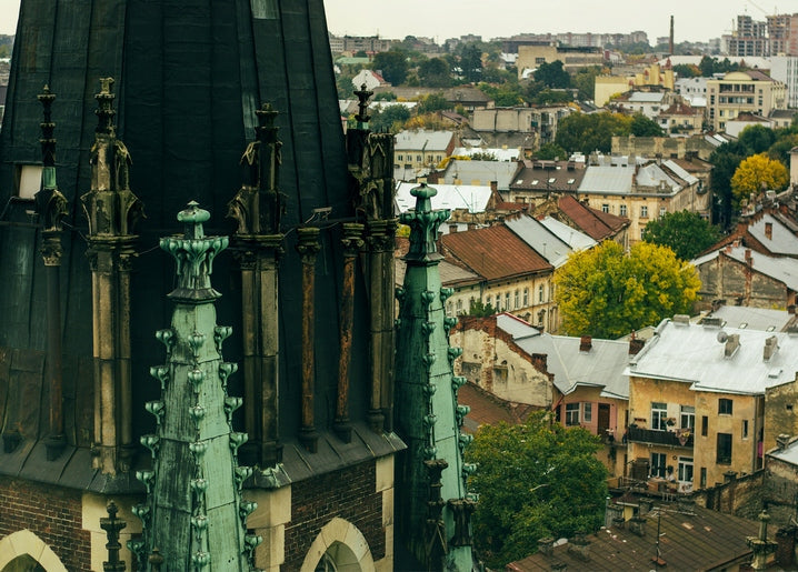 Weathered green-copper Gothic spires over Lviv's autumn rooftops