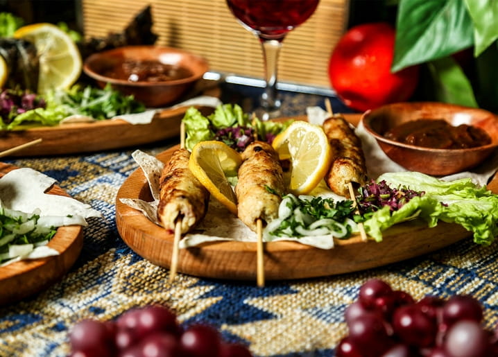 Gegrillte Fleischspieße mit Zitrone, Kräutern und Rotwein auf gemustertem Tuch