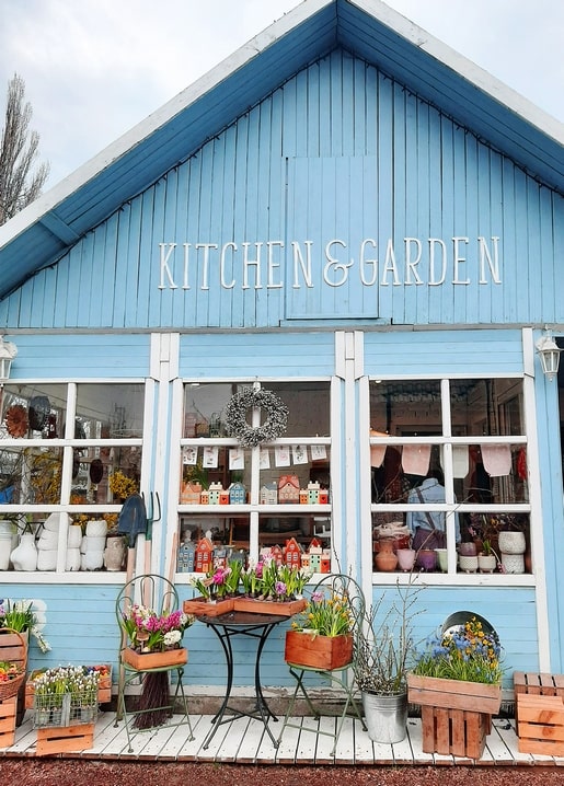 Sky-blue Kitchen & Garden pavilion at VDNG with spring flowers in wooden crates