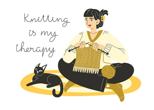 Illustration of a woman knitting with a black cat curled beside her, "Knitting is my therapy"