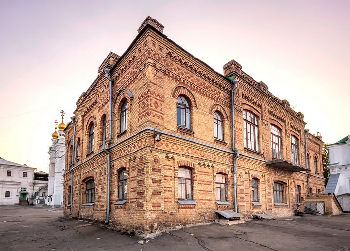 Цегляна будівля Києво-Печерської лаври із золотими банями на тлі