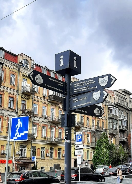 Black tourist signpost in central Kyiv pointing to St Volodymyr's Cathedral, the Opera and Golden Gates
