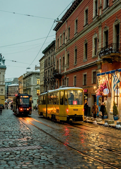 Жовтий трамвай №1022 на мокрій бруківці львівської вулиці у сутінках