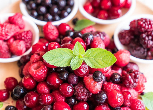 Overhead view of raspberries, blueberries, cranberries, and blackberries with mint