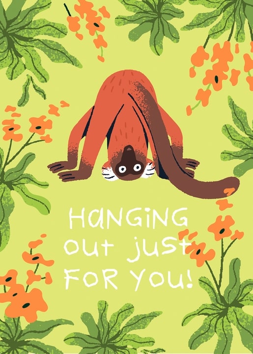 Red-brown monkey hanging upside down by its tail among tropical flowers
