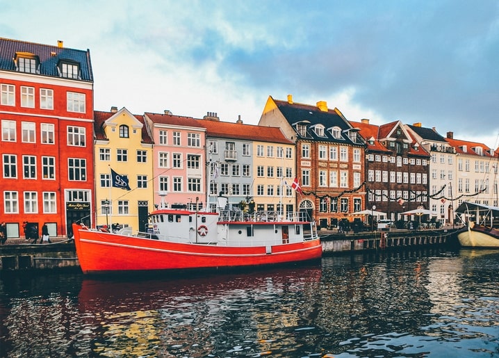 Colorful townhouses and a red boat along the Nyhavn canal in Copenhagen