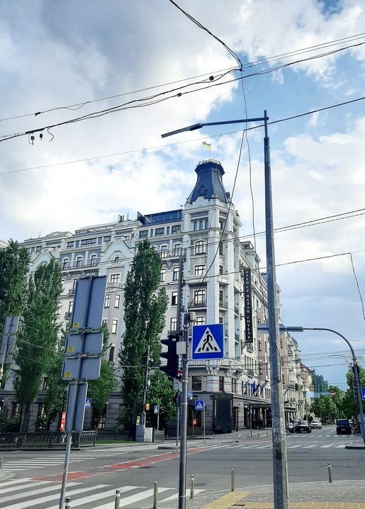 Domed corner tower of Kyiv's Premier Palace Hotel above a boulevard with tram wires