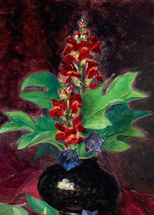 Still life painting of red snapdragons and violet bellflowers in a dark vase against a wine-red background
