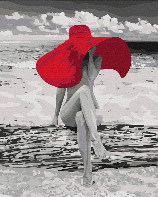 Monochromes Malen-nach-Zahlen-Motiv: Frau in rotem Tuch sitzt am Strand