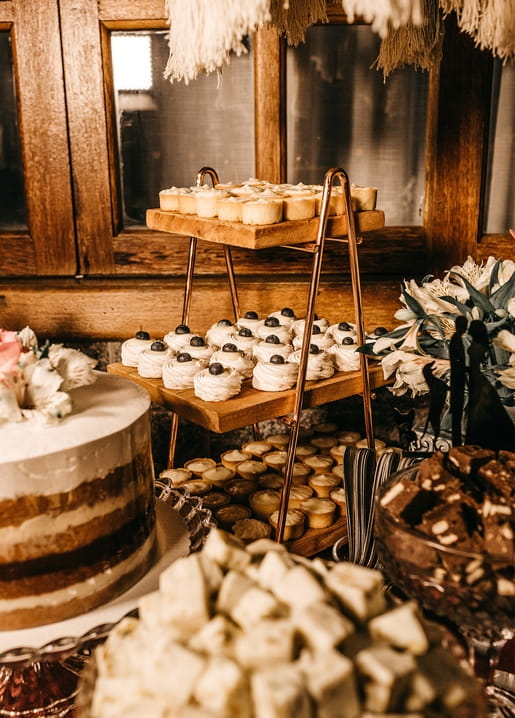 Wooden dessert stand with naked cake, meringues and mini tarts
