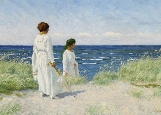 Zwei Frauen in weißen Kleidern gehen durch Dünengras zum Meer