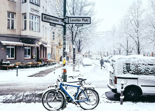Snow-covered Berlin street at Lausitzer Platz with a bicycle and van