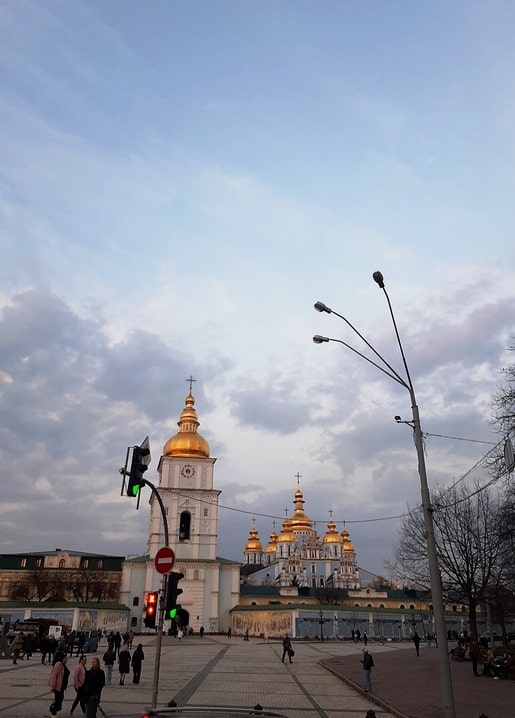 Golden domes of St. Michael's Monastery glowing at dusk over Kyiv's Mykhailivska Square