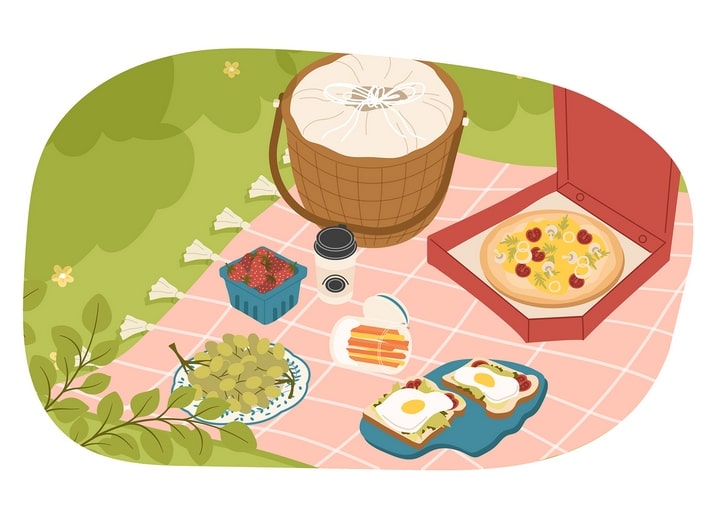 Checkered picnic blanket with basket, pizza, strawberries, and sandwiches