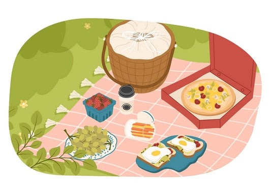 Checkered picnic blanket with basket, pizza, strawberries, and sandwiches