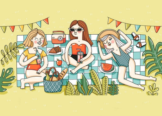 Three women having a summer picnic on a checkered blanket with watermelon and bunting flags