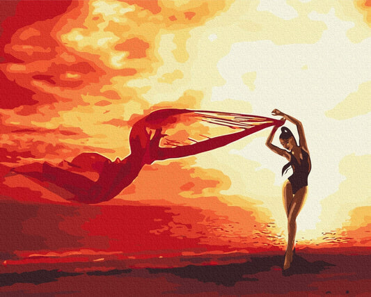 Silhouette einer Tänzerin mit wehendem roten Schal vor orangefarbenem Sonnenuntergang