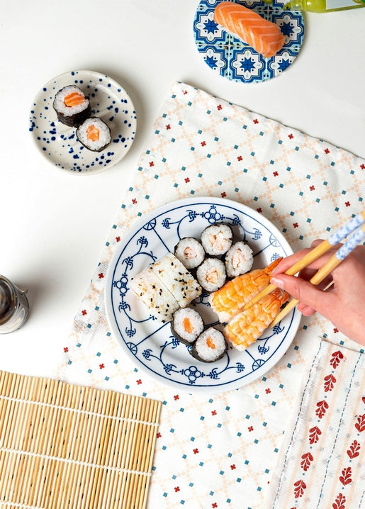 Sushi and salmon nigiri platter on a blue Japanese-style plate with chopsticks