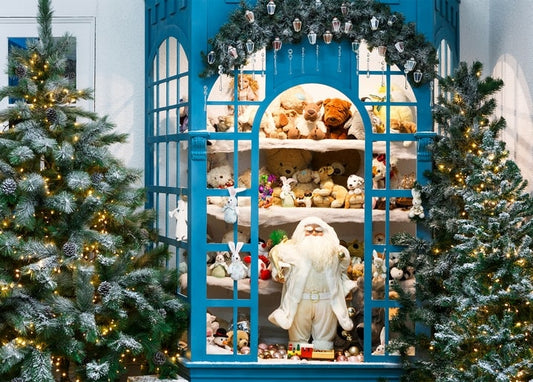 Blue toy shop display cabinet with Santa Claus figure, teddy bears, and snow-flocked Christmas trees