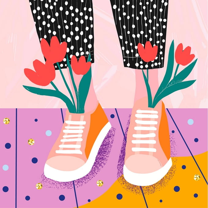 Rote Tulpen wachsen aus rosa Sneakers auf einem mit Konfetti bedeckten Boden
