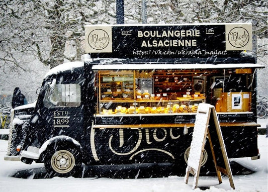 Schwarzer Vintage-Bäckerwagen mit hell erleuchtetem Schaufenster auf verschneiter Straße bei Schneefall