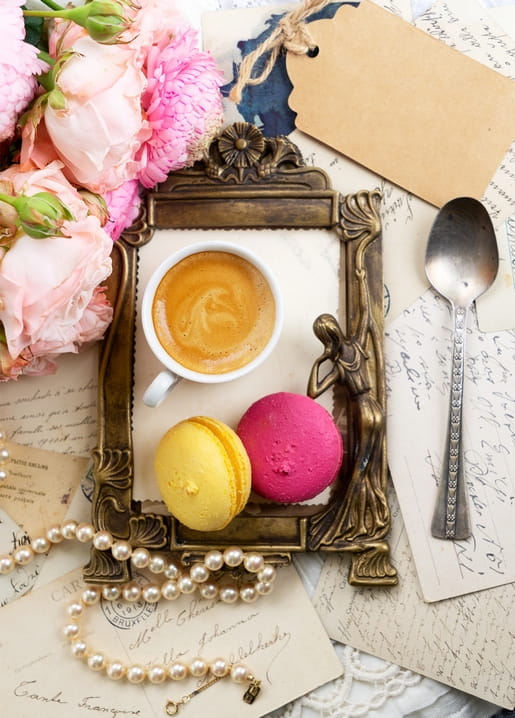 Espresso and pink macarons in an ornate vintage frame with roses and pearls