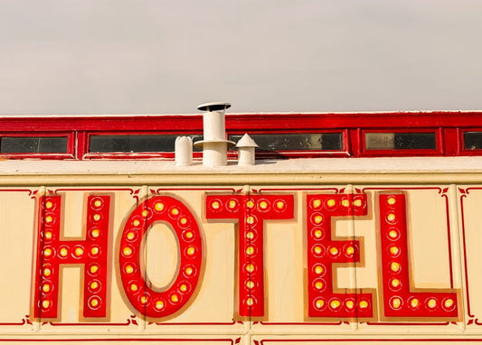Nahaufnahme einer alten, rot leuchtenden HOTEL-Leuchtreklame auf cremefarbenen Fliesen