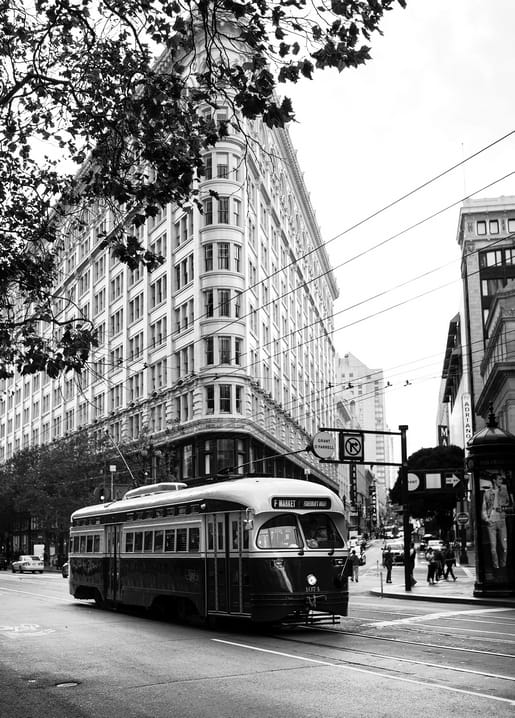Schwarzweißfoto einer Vintage-Straßenbahn vor einem Flatiron-Gebäude