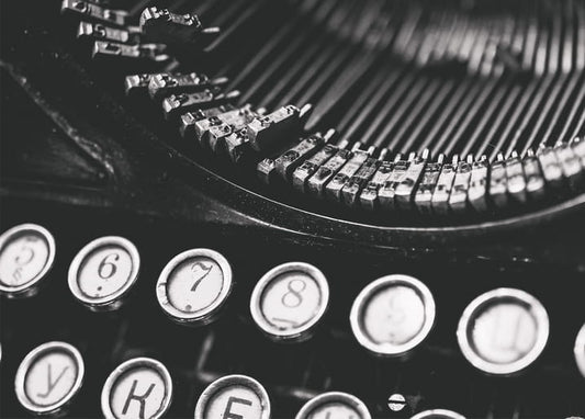 Black-and-white close-up of vintage typewriter keys and typebars