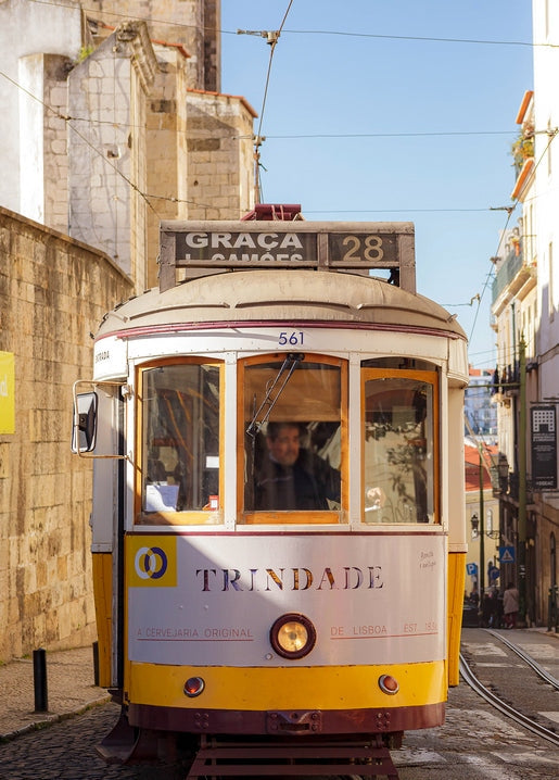 Vintage yellow tram number 28 on a cobblestone street in Lisbon