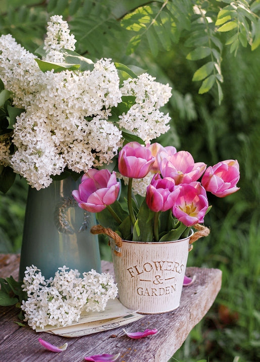 White lilac and pink tulips arranged on a wooden garden bench