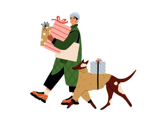 Woman in a green coat carrying wrapped Christmas gifts beside her dog with a gift box on its back